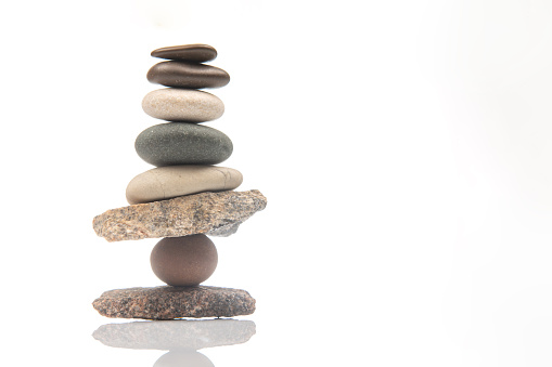 pyramid of stacked stones on a white background. stabilization and balance in life