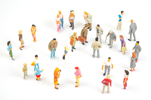 miniature people. group of different people communicate with each other on a white background. concept of communications and relations in society.