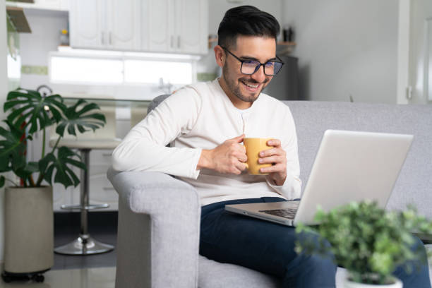 istock Happy man at home talking a video call while drinking coffee 1804788163