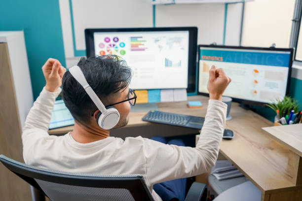 집에서 컴퓨터로 작업하고 성취를 축하하는 남자의 뒷모습 - office chair cheering ecstatic success 뉴스 사진 이미지