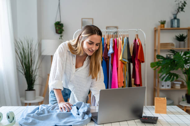 istock smiling young fashion designer using laptop while working at table in office 1804806611