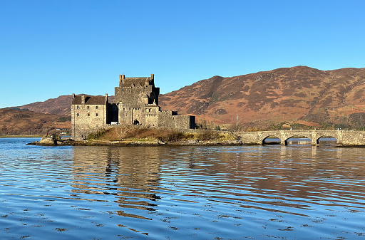 Dornie, Scotland, UK - November 17th, 2023: A high tide view of Loch Duich and Eilean Donan Castle during the daytime.