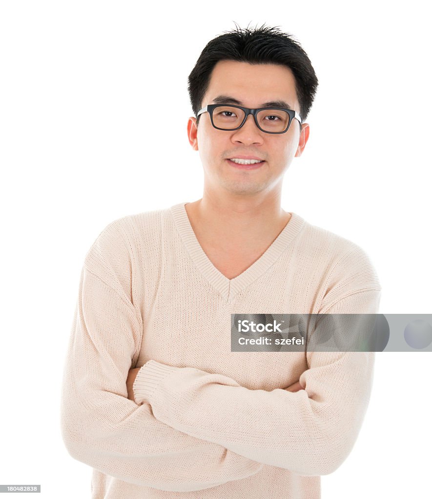 Smiling Asian man in glasses and sweater with arms crossed Front view headshot Asian man in casual wear standing isolated on white background. Asian male model. Headshot Stock Photo