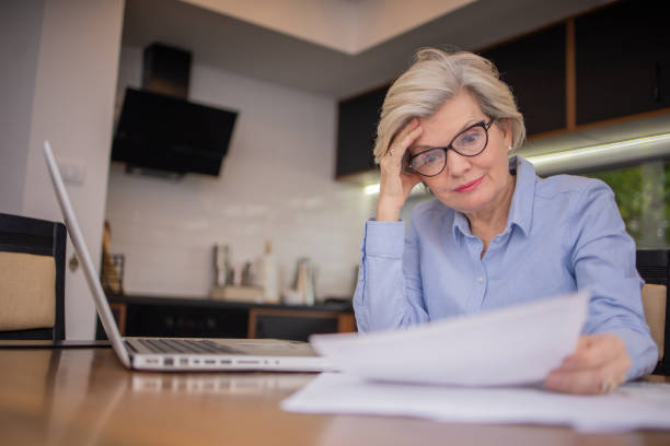 istock Senior woman going through paperwork 1804854566