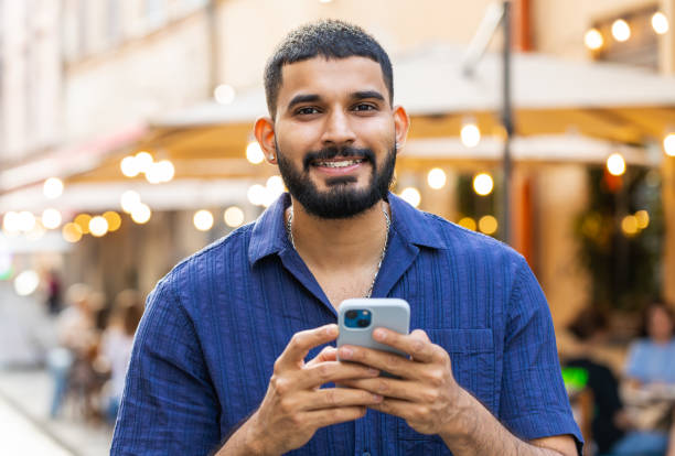 istock Young man use smartphone typing text messages browsing internet finishing work looking at camera 1804857938