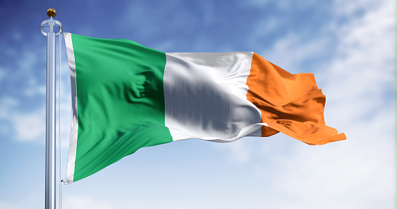 Ireland national flag waving in the wind on a clear day. Vertical tricolour of green, white, and orange. European Union state member. 3d illustration render. Fluttering fabric.