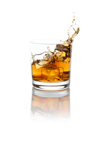Studio isolated splashing whiskey over white background. Clipping path included.