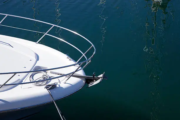 Close up of the bow of a luxury yacht tied up in a harbour.