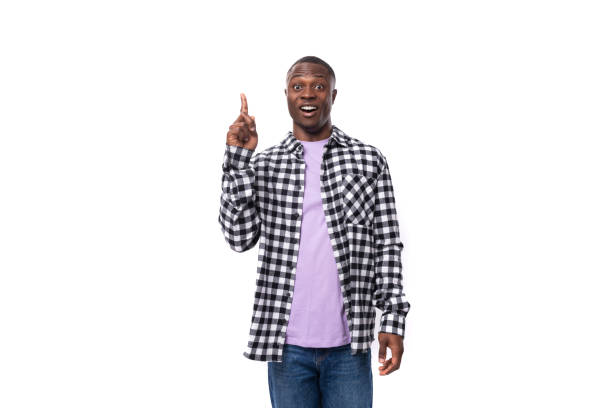 istock young smart african man dressed in a plaid shirt points a finger towards an advertisement on an isolated white background with copy space 1804880600