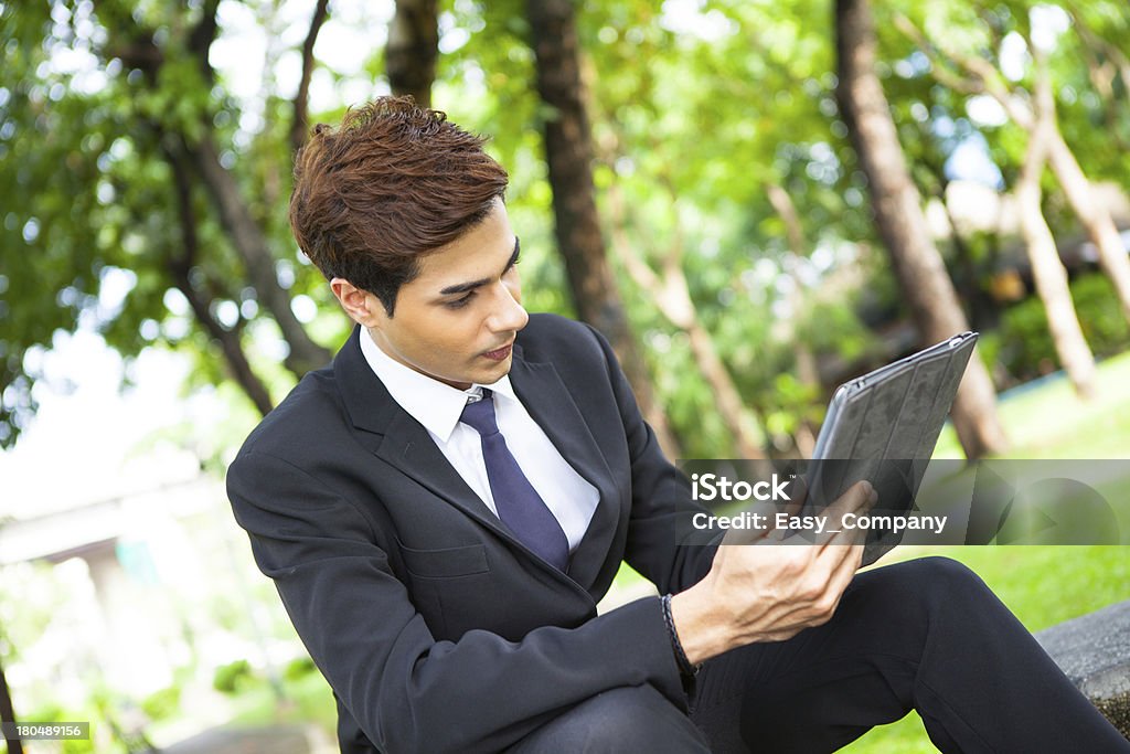 Uomo d'affari che lavorano all'aperto con digital tablet PC al Parco. - Foto stock royalty-free di Adulto