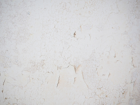 Ceiling of an old apartment. Crumbling plaster. The housing requires renovation. Background made of peel-off coating. Poverty