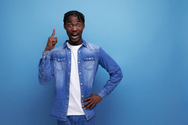istock smart stylish american young man with dreadlocks points finger to the side 1804939732