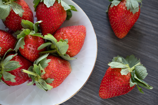 Close up of fresh ripe red wild strawberries growing in garden in summer