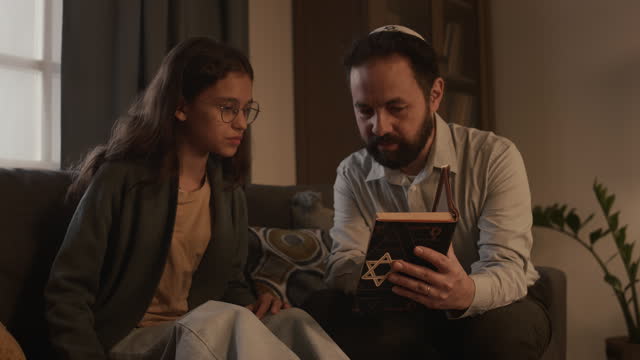 Jewish Man Studying Torah Together with Granddaughter at Hanukkah