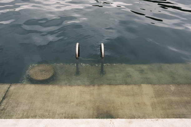 concrete platform on calm sea background. concrete beach with metal handrails. nature pool. horizon. waterline background. seawater surface. minimalistic background