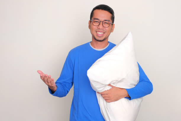 istock Adult Asian man smiling happy while holding a pillow 1805056247