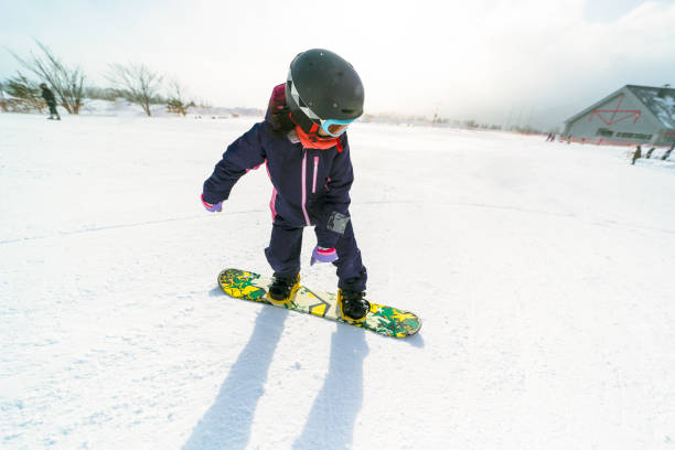 istock Young girl snowboarding for the first time 1805074910