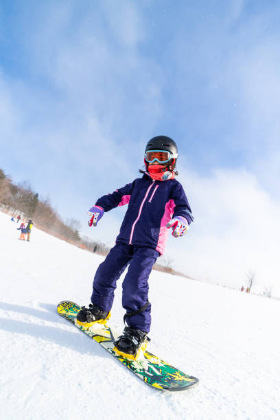 Young girl snowboarding for the first time A young Japanese girl trying snowboarding for the first time. japanese snowboarder stock pictures, royalty-free photos & images