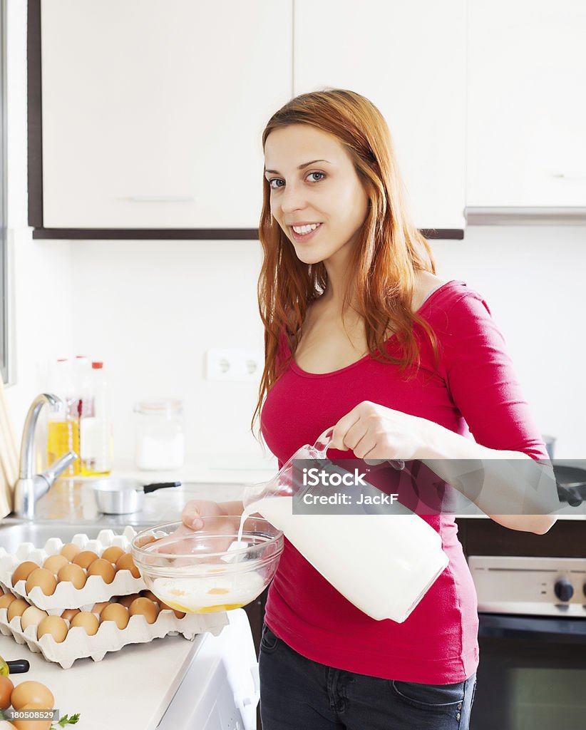 Donna fare uova strapazzate con latte - Foto stock royalty-free di Abbigliamento casual