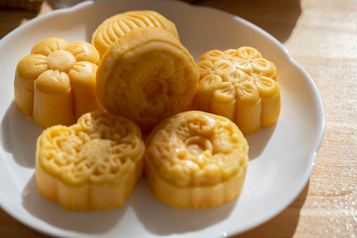 Tasty mooncakes and cup of tea on wooden table