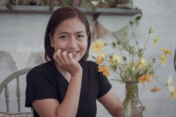 istock Woman arranging flowers in a vase 1805100329