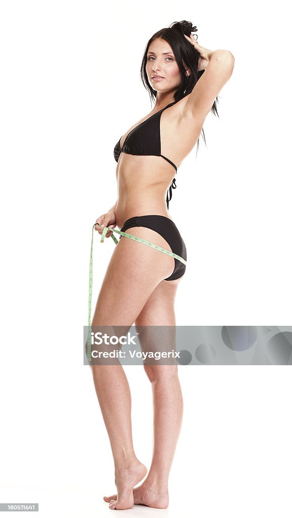 brunette girl bikini waistline de medición cinta - Foto de stock de 20 a 29 años libre de derechos