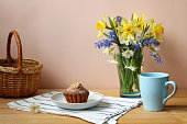 still-life, bouquet with daffodils, garden flowers. spring, rural composition, cottage core. cupcakes.