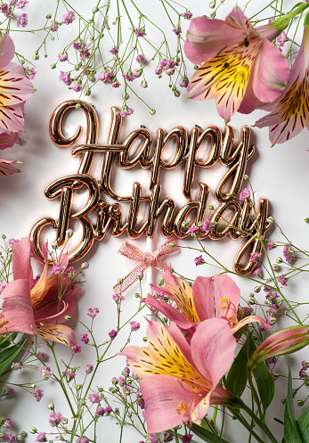 Alstroemeria flower commonly called Peruvian lily or Inca lily, with small purple flowers isolated on white for a birthday. Delicate flowers and birthday card in golden letters. Interesting floral illustration or background