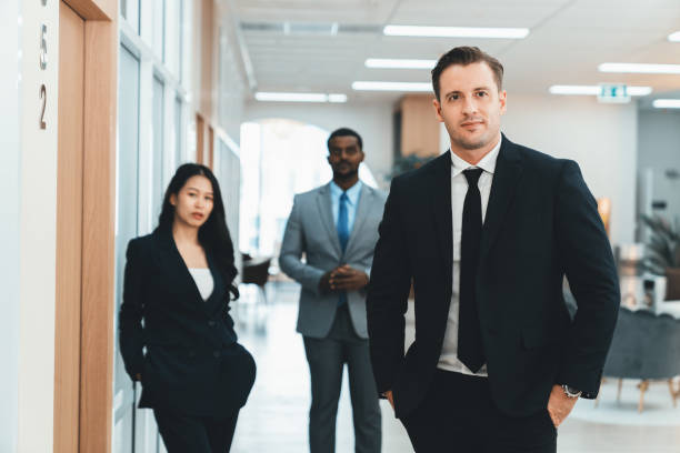 istock Businessman standing with arm folded while coworker stand behind. Ornamented. 1805125615