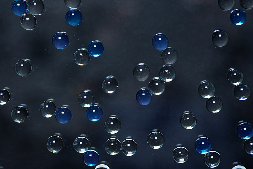 Abstract background with bubbles on a dark grey, in closeup. Full frame