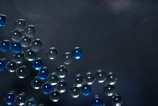 Abstract background with bubbles on a dark grey, in closeup. With copy space