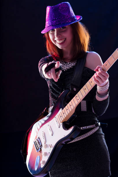 istock Guitarist in purple hat points, joy radiates 1805141806