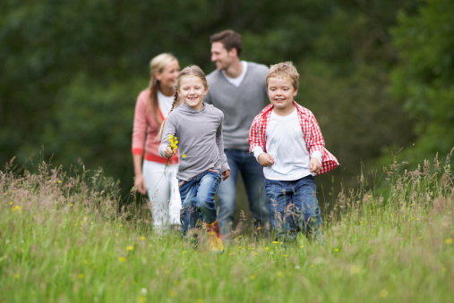 Family On Walk In Countryside, Walking Towards Camera And Smiling