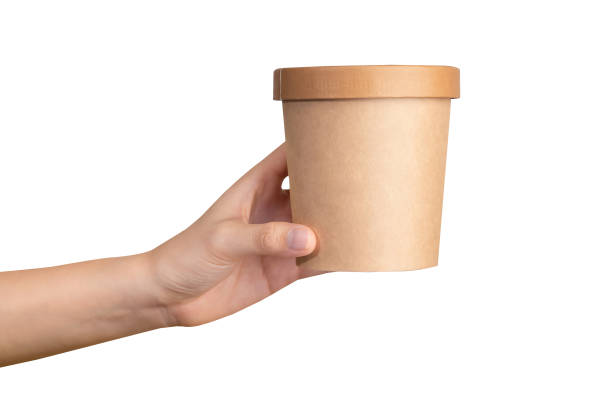 istock Clipping path, hand holds craft paper soup cup on isolated white background. 1805171988