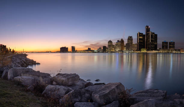 Detroit, Michigan - Skyline at Dusk The Detroit skyline as seen from across the Detroit River, in Windsor, Ontario, Canada. detroit michigan stock pictures, royalty-free photos & images