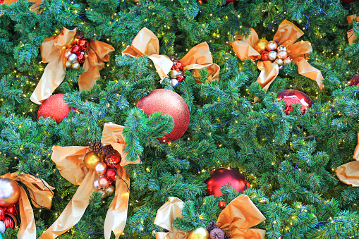 Christmas balls and light hanging on pine tree branches. Xmas winter background.