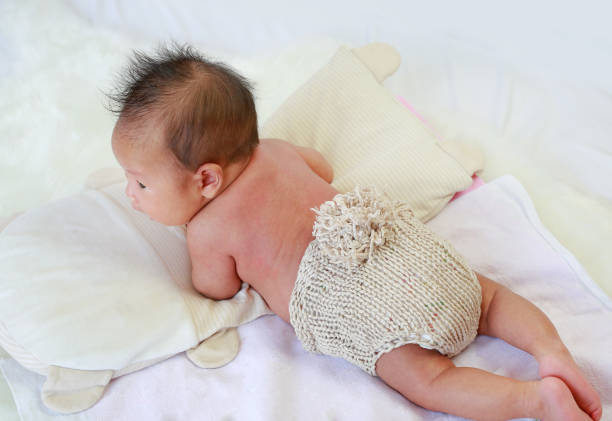 istock Back view upside down of infant baby lying on the bed. 1805197214