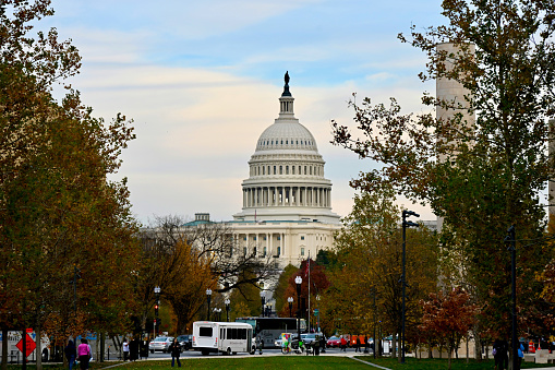 Washington, D.C., USA - November 20, 2023: Tourists walk near the United States Capitol building on a late fall afternoon.