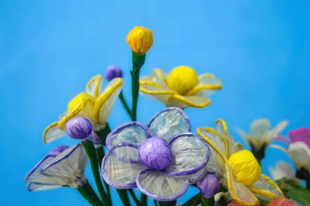 plastic flower bouquets for decoration on a plain blue wall background