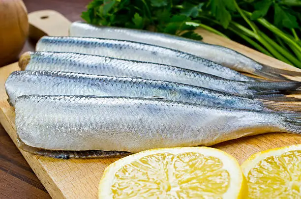 Raw herrings on wooden board