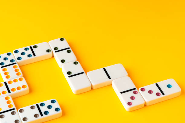 Domino tiles on yellow background studio shot