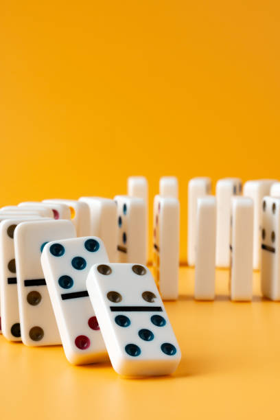 istock Row of domino tiles on yellow studio background 1805281810