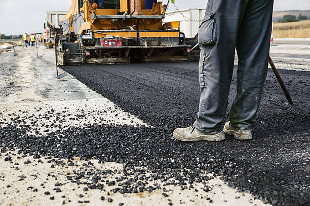Works on the highway Worker operating asphalt paver machine during road construction and repairing works drudgery photos stock pictures, royalty-free photos & images