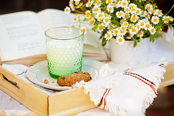 Glas Milch und Keksen und Blumen. – Foto