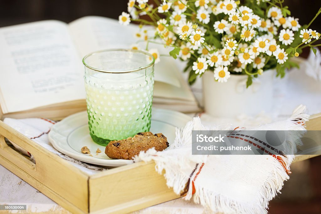 Bicchiere di latte con biscotti e fiori. - Foto stock royalty-free di Affamato