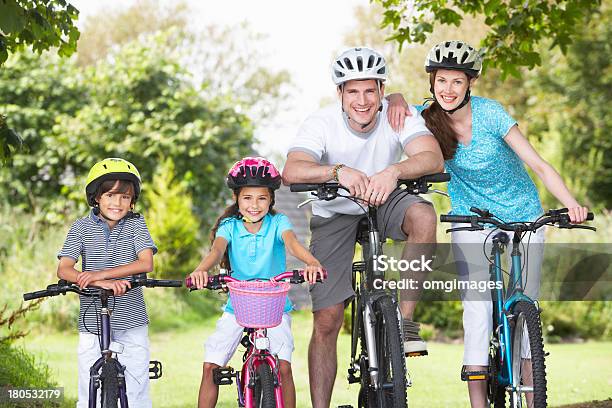 Smiling Family Of Four In Riding Gear On Bicycles Stock Photo - Download Image Now - Cycling, Family, Bicycle