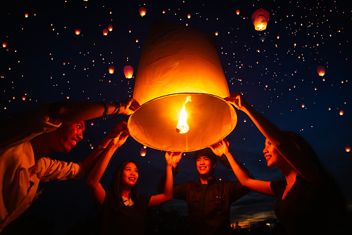 Asian couple traveller setting yi peng  lantern in loi krathong festivities celebration in chiang mai, Thailand