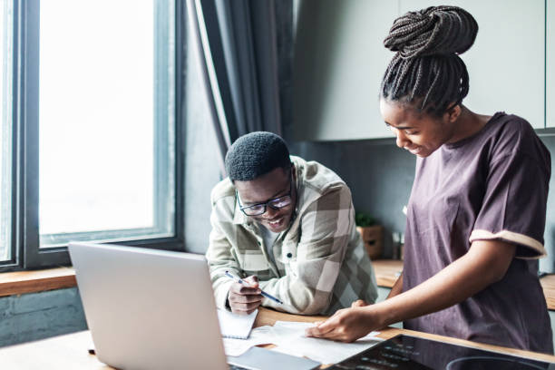 istock Young black couple calculating utility bills using laptop at the kitchen 1805363923