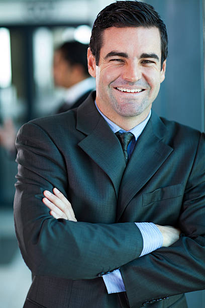 istock cheerful businessman with arms folded 180537162