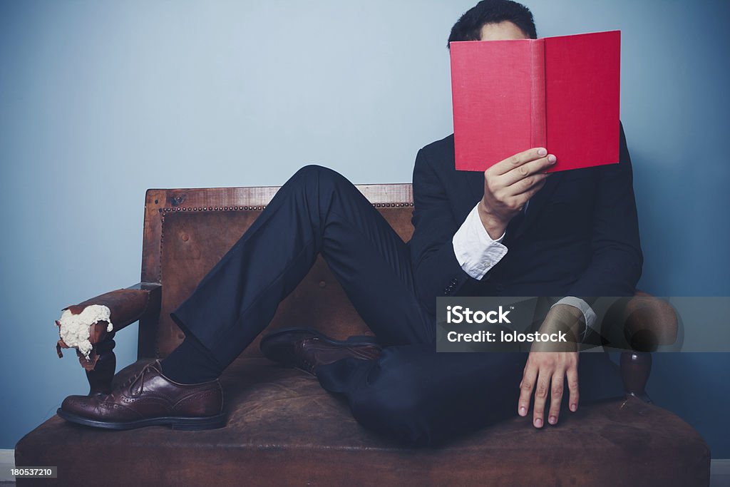 Homme d'affaires sur canapé, lecture - Photo de Costume habillé libre de droits